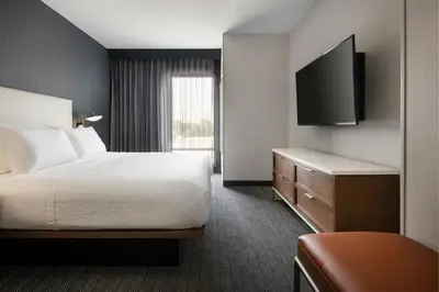 a hotel room with a bed and a flat screen tv at Courtyard by Marriott Fresno Clovis in Clovis