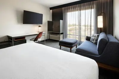 a hotel room with a bed and a desk at Courtyard by Marriott Fresno Clovis in Clovis
