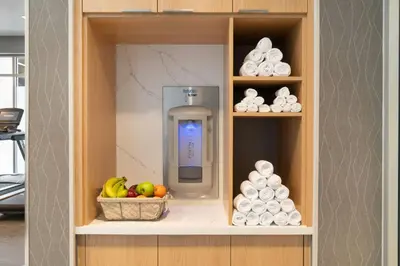 a drink dispenser in a cabinet with a basket of fruit at Courtyard by Marriott Fresno Clovis in Clovis