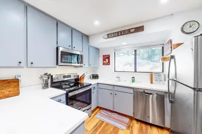 a kitchen with white cabinets and a stainless steel refrigerator at Lake Therapy in Lakeshore