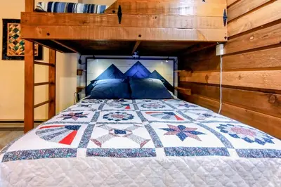 a bedroom with a bed with a quilt on it at Lake Therapy in Lakeshore
