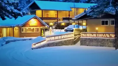 a house covered in snow at night with lights at Holiday Haus in Mammoth Lakes