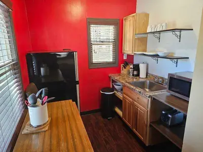 a kitchen with a black refrigerator and a red wall at Holiday Haus in Mammoth Lakes