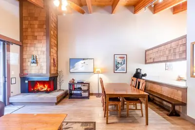 a living room with a table and a fireplace at Cozy Aspen Grove 2 bed 2 bath condo in Truckee