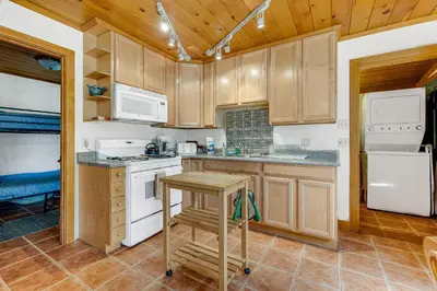 a kitchen with white appliances and wooden cabinets at Yosemite Mountain Cottage in Groveland