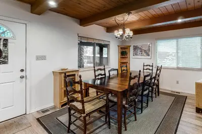 a dining room with a wooden table and chairs at Snowpeak Chalet in Camp Connell