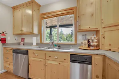 a kitchen with wooden cabinets and a sink and a window at Moonrise Lodge - A Large Vacation Home in Mariposa in Mariposa