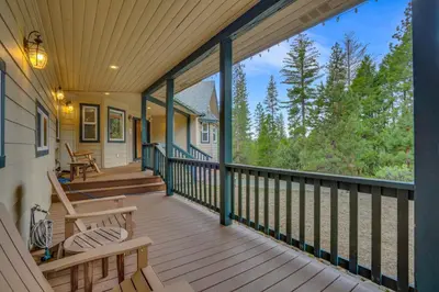a screened porch with rocking chairs on a house at Moonrise Lodge - A Large Vacation Home in Mariposa in Mariposa