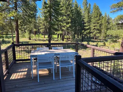 a wooden deck with a table and chairs on it at Annie's Loop, Gray's Crossing 10215 in Truckee