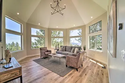 a living room with a couch and chairs and windows at Hot Tub, Pool Table Luxe Reno Chalet with Mtn View! in Reno