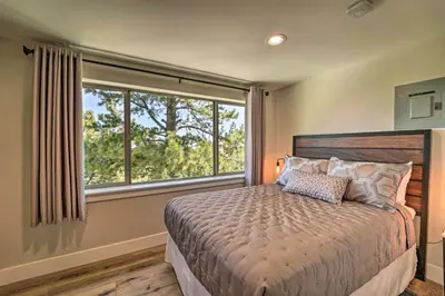 a bedroom with a bed and a large window at Hot Tub, Pool Table Luxe Reno Chalet with Mtn View! in Reno