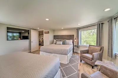 a bedroom with two beds and a chair and a tv at Hot Tub, Pool Table Luxe Reno Chalet with Mtn View! in Reno
