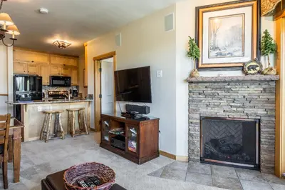 a living room with a fireplace and a television at Juniper Springs Lodge #413 - Luxury Ski in Ski out! 2 Bedroom in Mammoth Lakes