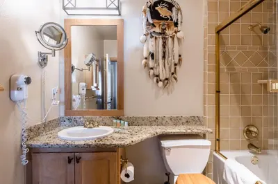a bathroom with a sink and a toilet and a mirror at Juniper Springs Lodge #413 - Luxury Ski in Ski out! 2 Bedroom in Mammoth Lakes