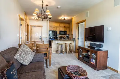 a living room with a couch and a dining room at Juniper Springs Lodge #413 - Luxury Ski in Ski out! 2 Bedroom in Mammoth Lakes