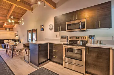 a kitchen with stainless steel appliances and a dining room at Contemporary Mountain Retreat - Walk to Slopes! in Mammoth Lakes