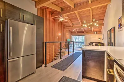 a kitchen with a stainless steel refrigerator and wooden walls at Contemporary Mountain Retreat - Walk to Slopes! in Mammoth Lakes
