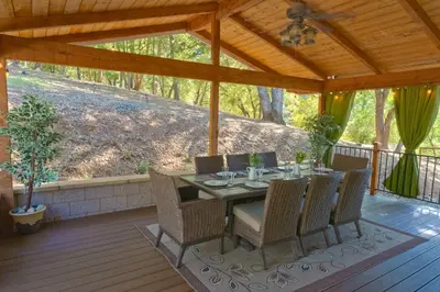 a patio with a table and chairs on a deck at Cozy mountain retreat with lake views near Yosemite in Groveland