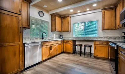 a kitchen with wooden cabinets and a counter with stools at 12R Hilltop Haven in North Wawona