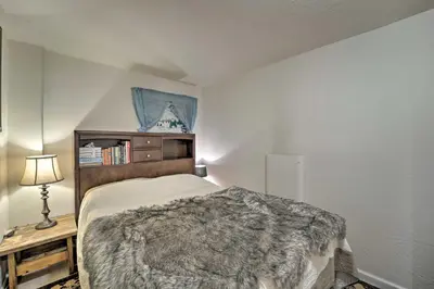 a bedroom with a bed and a table with a lamp at Half-Mi to Trails Rustic Soda Springs Cabin! in Soda Springs