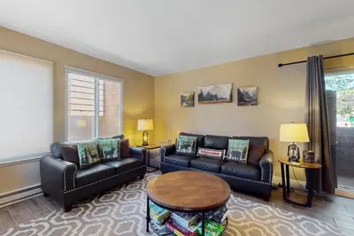 a living room with two couches and a table at 11529 Snowpeak Way #619 in Truckee