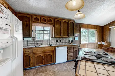 a kitchen with wooden cabinets and a white refrigerator at It's Cabin Time in Groveland