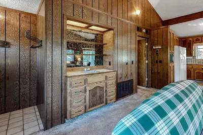 a kitchen with wooden walls and a sink at It's Cabin Time in Groveland