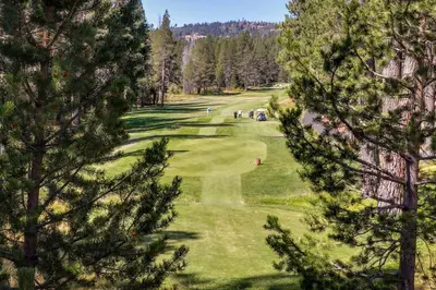 a view of a golf course through the trees at Hammock Holidays in Truckee