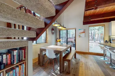 a kitchen and dining room with a table and bookshelves at Hammock Holidays in Truckee