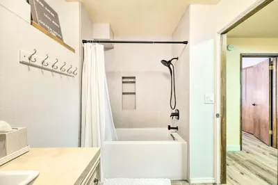 a white bathroom with a tub and a shower at Pine Mountain Cabin with Hot Tub, 2 Mins to Marina! in Groveland