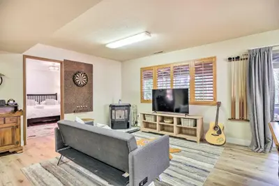 a living room with a couch and a television at Pine Mountain Cabin with Hot Tub, 2 Mins to Marina! in Groveland