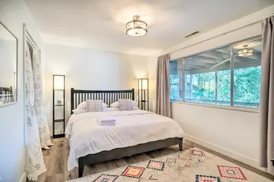 a bedroom with a bed and a large window at Pine Mountain Cabin with Hot Tub, 2 Mins to Marina! in Groveland