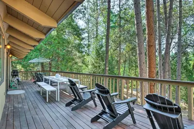 a wooden deck with chairs and a table on it at Pine Mountain Cabin with Hot Tub, 2 Mins to Marina! in Groveland