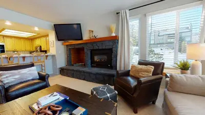 a living room with a fireplace and a table at Silver Bear #21 condo in Mammoth Lakes