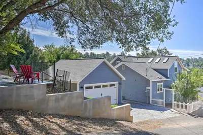 a blue house with a garage and a red chair at Sierra Sunset Inn - 3 Miles to Placerville! in Placerville