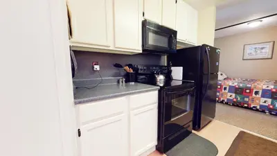 a kitchen with white cabinets and a black refrigerator at Crestview #25 condo in Mammoth Lakes