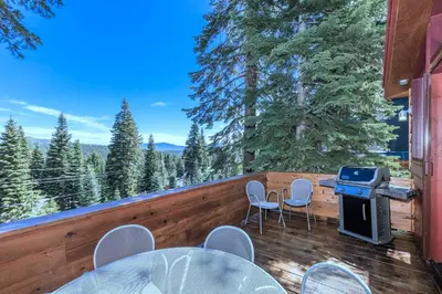 a deck with a grill and chairs and a table at Tahoe Donner Luxury, Sleeps 14, Hot tub, 3100 sqft in Truckee