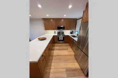 a kitchen with wooden cabinets and white counter tops at DNA Chalet - Newly Renovated Townhome @ Northstar in Truckee