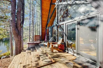 a screened in porch of a house with benches on a deck at Serene Lakes Splendor in Soda Springs