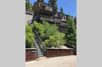 a large house with stairs in front of it at High Sierra Retreat with a view of Pinecrest lake in Pinecrest