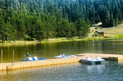 a group of boats on a dock in the water at High Sierra Retreat with a view of Pinecrest lake in Pinecrest