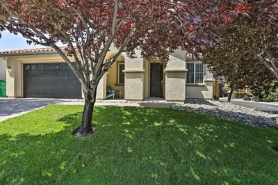 a tree in a yard in front of a house at 12 Mi to Riverwalk District Quiet Reno Retreat in Reno