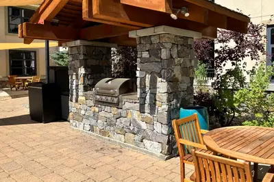 an outdoor grill with a wooden table and a table and chairs at Westin 617 in Mammoth Lakes