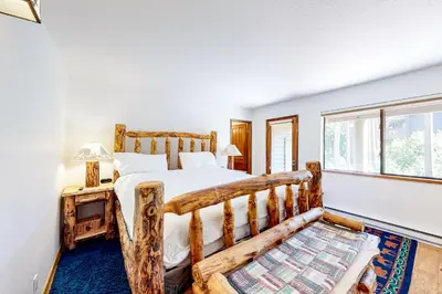 a bedroom with a wooden bed and a window at Forest Creek 12 in Mammoth Lakes