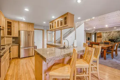 a kitchen with wooden cabinets and a table and chairs at Through the Trees in Truckee
