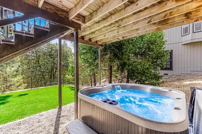a hot tub on a patio under a wooden roof at Harvest Moon Hideaway in Groveland
