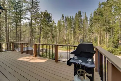 a grill on a wooden deck with trees in the background at Near Donner Lake and Skiing Soda Springs Cabin! in Soda Springs