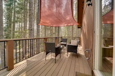 a screened porch with chairs and tables on a deck with trees at Near Donner Lake and Skiing Soda Springs Cabin! in Soda Springs
