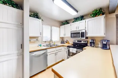 a kitchen with white cabinets and a sink at Sunrise 8 in Mammoth Lakes