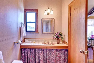 a bathroom with a sink and a mirror and a window at Mariposa Hotel Inn in Mariposa